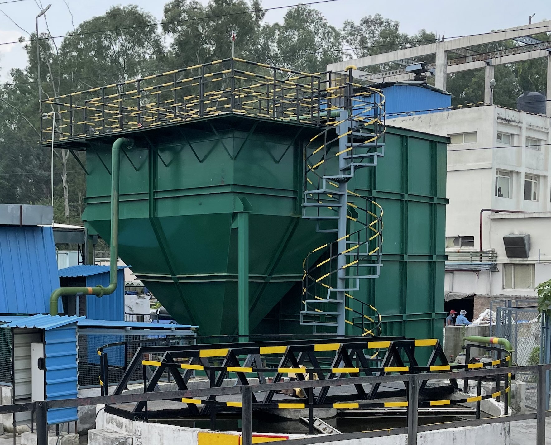 Green hopper-bottom ETP tank with spiral staircase and clarifier